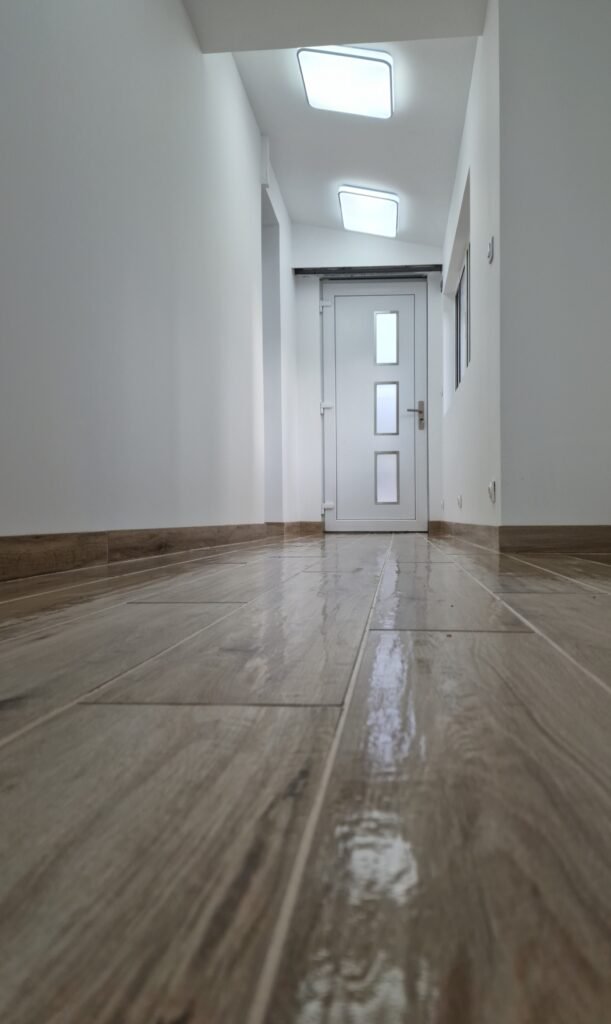 couloir rénové avec carrelage imitation bois et finitions blanches dans les Ardennes