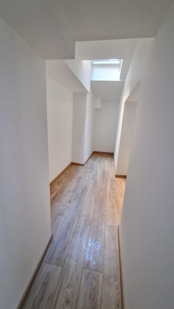 couloir rénové avec sol effet bois et finitions blanches après rénovation intérieure