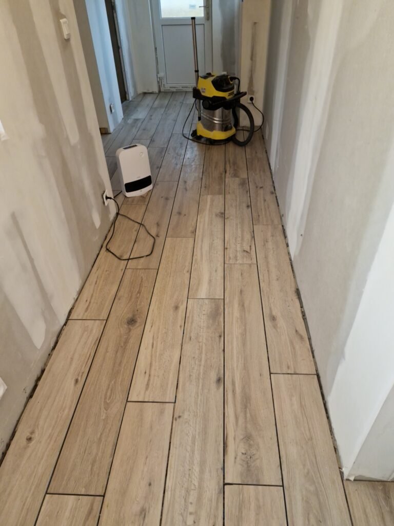 travaux de carreleur dans un couloir avec pose de carrelage imitation bois