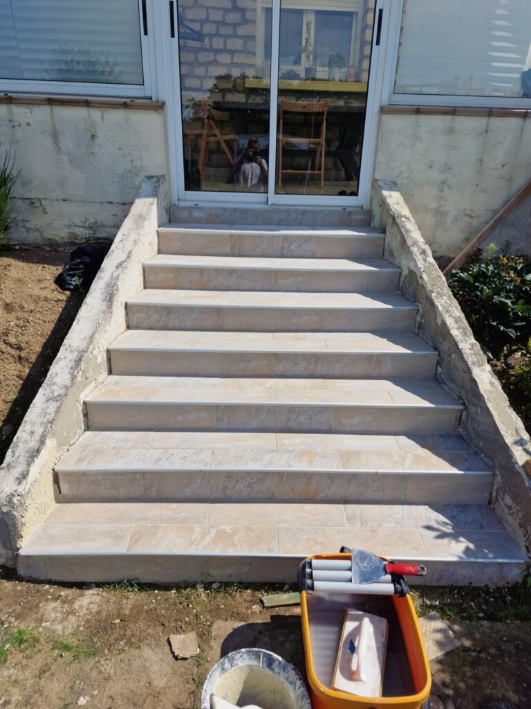 détail de la pose d’un carrelage effet pierre sur des marches extérieures