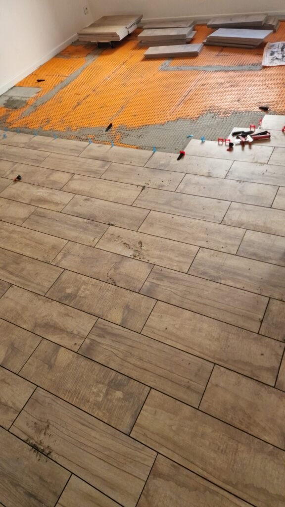 Pose de carrelage imitation parquet sur natte DITRA 25 à Moncy-Notre-Dame, dans les Ardennes.